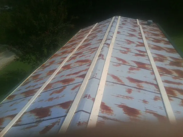 Rusted metal roof panels with new wood purlins before replacement — Storm Damage Roof Repair in Fayette City by Roofing Brothers