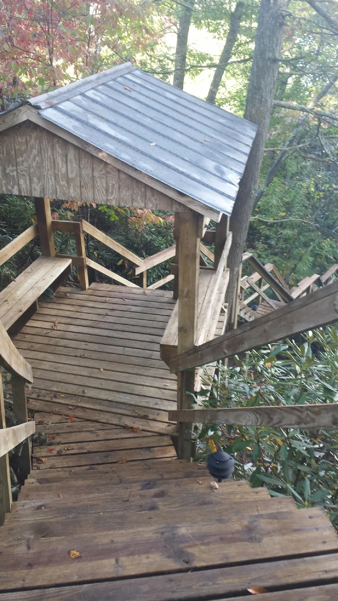 Metal roofed shelter over wooden steps on a wooded walkway — Skylight Repair & Installation work by our crew in Fayette City