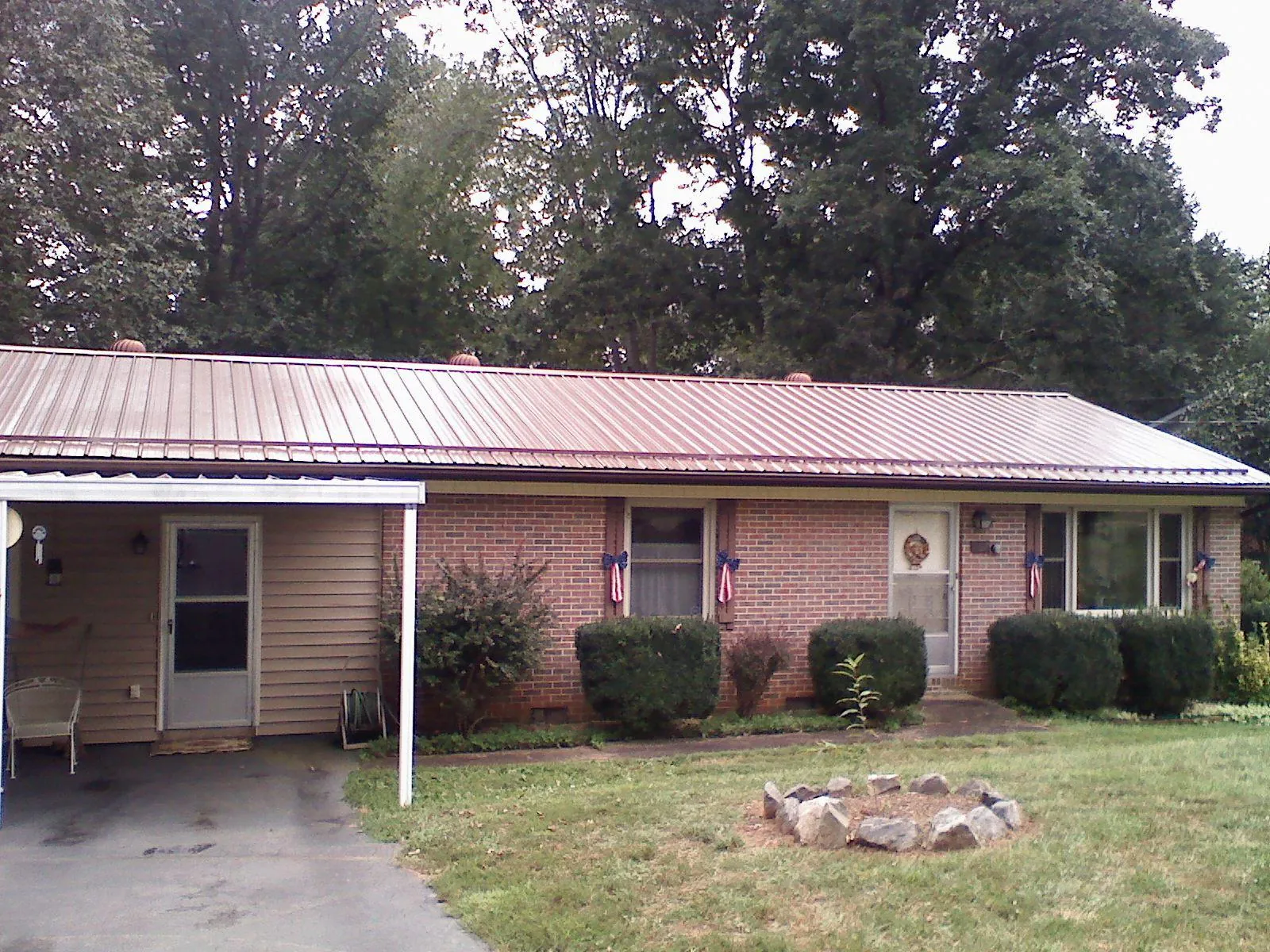 Bronze metal roof and carport on a brick ranch home — Roof Repair work by our crew in Fayette City